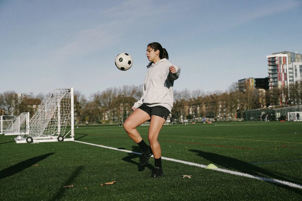 A girl playing soccer with a BEAR implant used to treat ACL tears