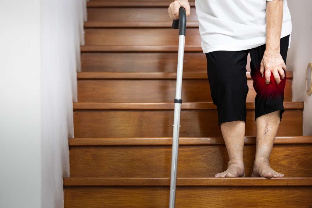an adult walking down the stairs with a knee injury